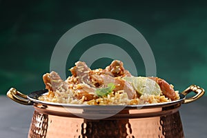 Dum chicken biriyani on a rustic background