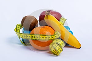 Dumbbell and apple, orange, banana, kiwi white background