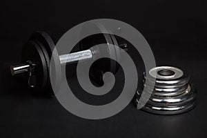 Dumbbell and barbell discs for workout on black background