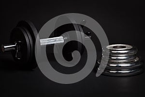 Dumbbell and barbell discs for workout on black background