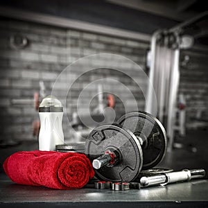 Dumbbell, barbell and workout in the gym. Copy space on black grunge wall and board background.