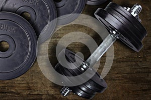 Dumbbell and weights on a wooden background