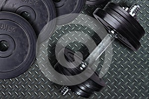Dumbbell and weights on a wooden background