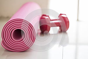 Dumbbell and yoga mat on table