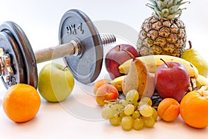 Dumbbells and assorted fruits and measure tape healthy lifestyle weight loss concept