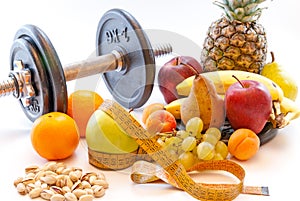 Dumbbells and assorted fruits and meter healthy lifestyle weight loss concept