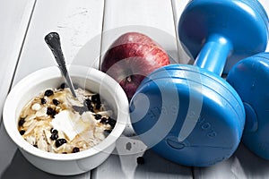 Dumbbells and bowl with yogurt