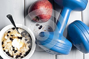 Dumbbells and bowl with yogurt