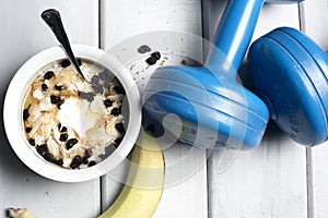 Dumbbells and bowl with yogurt