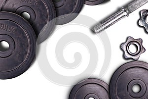 Dumbbells on carbon background. Dumbbells and weights are lying on the floor in the gym. Barbell set and gym equipment. Metal