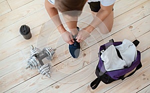 Dumbbells in living room interior on wooden floor with protein shake cup and gym bag