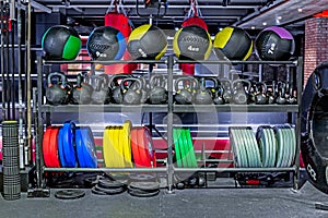Dumbbells, pancakes and weights, leather fitballs lying on the shelves. Gym. Equipment for gym photo