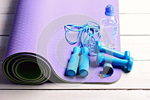 Dumbbells, measure tape and jump rope in cyan blue color