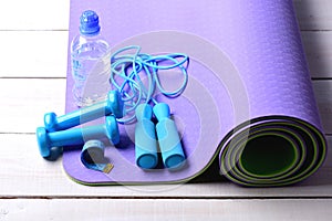 Dumbbells, measure tape and jump rope in cyan blue color