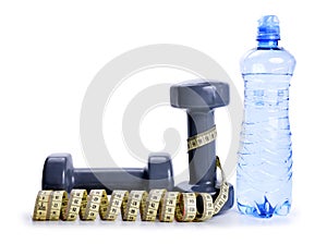 Dumbbells with measuring tape and bottle with drinking water isolated on white background.