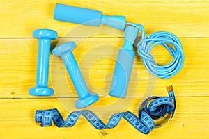Dumbbells, measuring tape and jump rope, top view