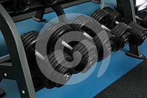 Dumbbells on rack in gym. Sport equipment