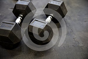 Dumbbells or weights on black rubber flooring tiles inside gym Concept for workout