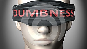 Dumbness can make things harder to see or makes us blind to the reality - pictured as word Dumbness on a blindfold to symbolize