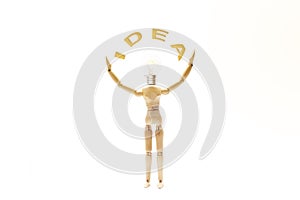 Dummy with the bulb head and arms up holding the word IDEA