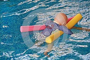 Dummy drowning training baby doll float in the pool with noodles