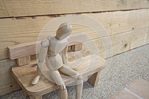 Dummy wood man acting alone wooden chair