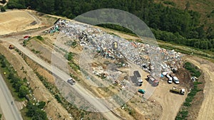 Dump municipal solid waste landfill city, drone aerial video shot, bulldozer compacts garbage trash rubbish litter photo