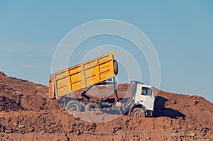 Dump truck is dumping gravel on an excavation site