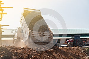 Dump truck fill soil into the pool beside the construction site