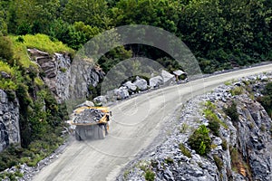 Dump truck hauling rocks in a mining and construction site.