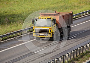 dump truck moves along country road