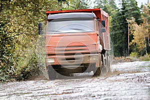 The dump truck moves on a muddy road