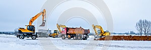 Dump truck is moving down sand on construction site. Leveling the ground.