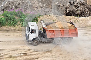 Dump truck transports sand in open pit mine. In the production of concrete, concrete for the construction using coarse sand.