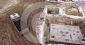 Dump truck Transports Soil On Construction Site. top view dump truck unloading soil sand construction site. big