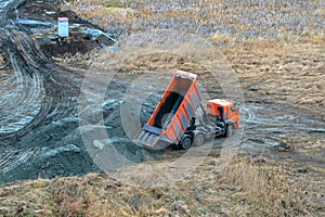 Dump truck unloading process. Dumper truck unloading earth material or soil at construction site during land improvement