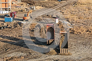 Dump truck unloading process. Dumper trucks unloading earth material, soil at construction site during land improvement