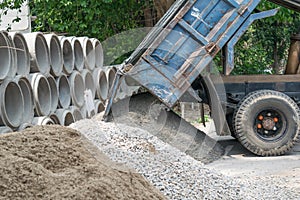 Dump truck unloading sand at construction site