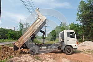 Dump truck unloading soil at construction site