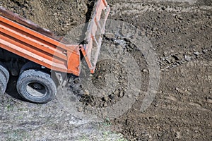 Dump truck unloading soil at construction site