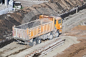 Dump truck unloading soil at construction site