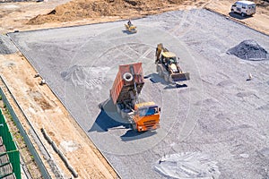 Dump truck unloads asphalt at the construction site of the school stadium