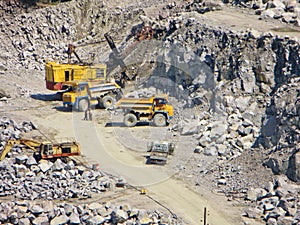 Dump trucks and excavators in the granite quarry