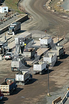 Dump trucks lined up at a rock quarry