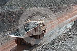 Dumper truck with loaded stones driving along in a quary. mining