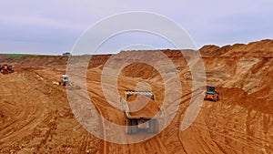 Dumper truck transporting sand in quarry. Aerial view of sand work