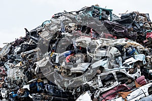 Dumping ground. Scrap metal heap. Compressed crushed cars is returned for recycling. Iron waste ground in the industrial area.