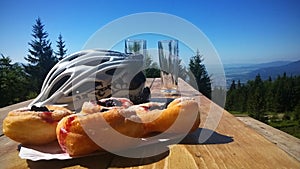 Halušky a cyklistická prilba na stole s výhľadom z kopca.