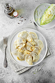 Dumplings, filled with cabbage. Russian, Ukrainian or Polish dish: varenyky, vareniki, pierogi, pyrohy. Food photo. flat lay