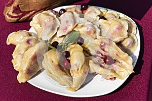 Dumplings, filled with cherries, berries. Pierogi, varenyky, vareniki, pyrohy - dumplings with filling